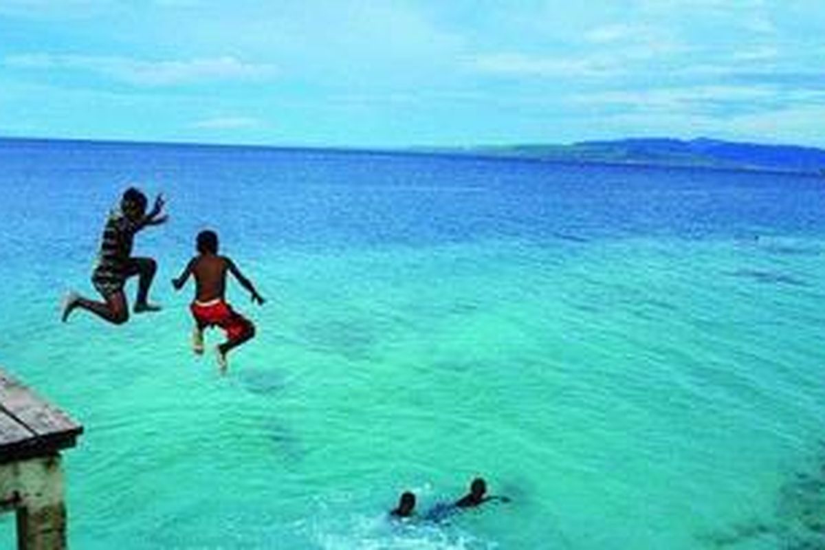 Dua bocah melompat ke laut di pantai Liang, di Ambon, yang jernih dan tenang, Minggu (28/3/2010). Pantai Liang adalah salah satu pantai berpasir putih yang banyak dikunjungi orang.