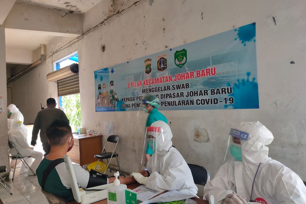 Petugas Puskesmas Kecamatan Johar Baru melakukan pemeriksaan swab kepada pedagang di Pasar Johar Baru, Jakarta Pusat, Kamis (18/6/2020)