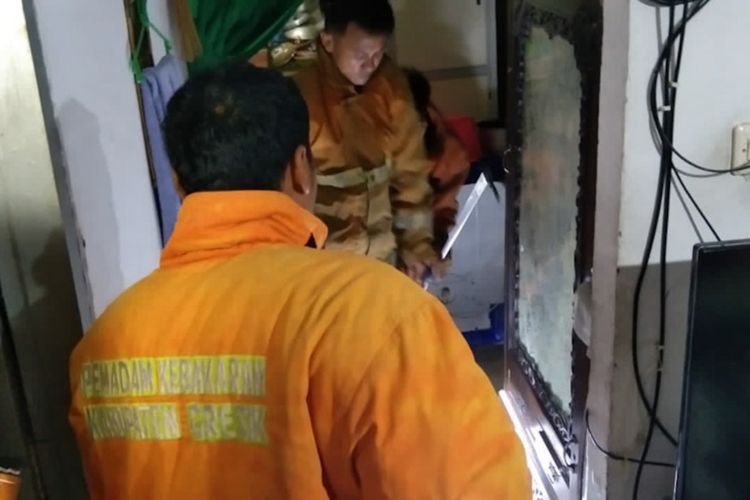 Petugas Damkar Gresik saat melakukan upaya evakuasi ular sanca dari rumah Bhiro, Selasa (11/1/2022).
