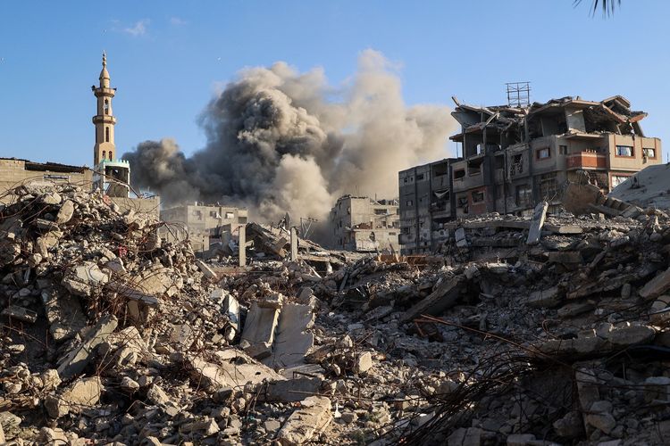 Asap membubung dari bangunan yang diserang Israel di kamp pengungsian Bureij di tengah Jalur Gaza, Palestina, Minggu (19/10/2025). Serangan terjadi ketika gencatan senjata Gaza berlaku.