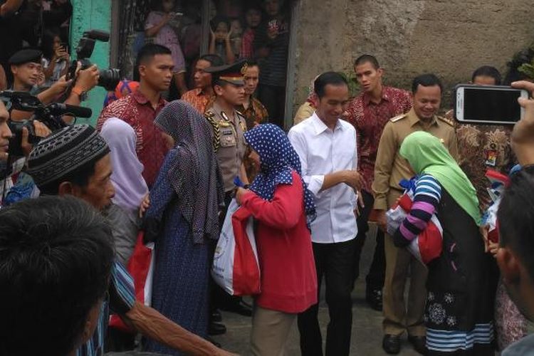 Presiden Joko Widodo menyaksikan pembagian sembako kepada warga di Panaragan, Bogor, Jawa Barat, Selasa (28/6/2016).