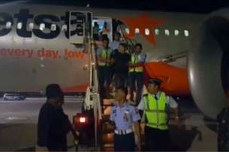 Aparat keamanan Indonesia terlihat menggiring para penumpang mabuk yang mengakibatkan sebuah penerbangan maskapai JetStar melakukan pendaratan darurat di Denpasar, Bali.