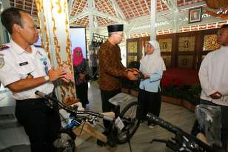 Wali Kota Bandung Ridwan Kamil saat memberikan hadiah sepeda kepada Annisa Sadmahfudz (15) siswa SMP 39 Kota Bandung yang giat bersepda ke sekolah, di Pendopo Kota Bandung, Jum'at (14/10/2016). KOMPAS.com/DENDI RAMDHANI