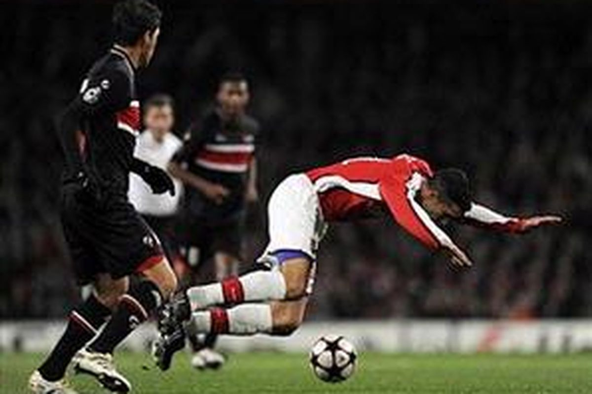 Penyerang Arsenal, Robin van Persie (kanan) mendapat pengawalan ketat pemain AZ Alkmaar. Namun, Arsenal akhirnya mampu menang 4-1.