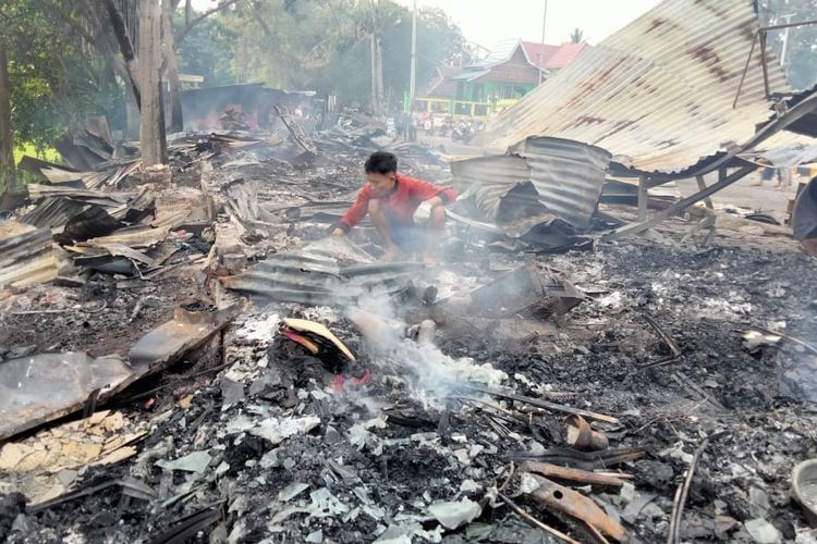 Pemilik kios saat memeriksa puing-puing bangunan setelah hangus terbakar pukul 3.30 WIB