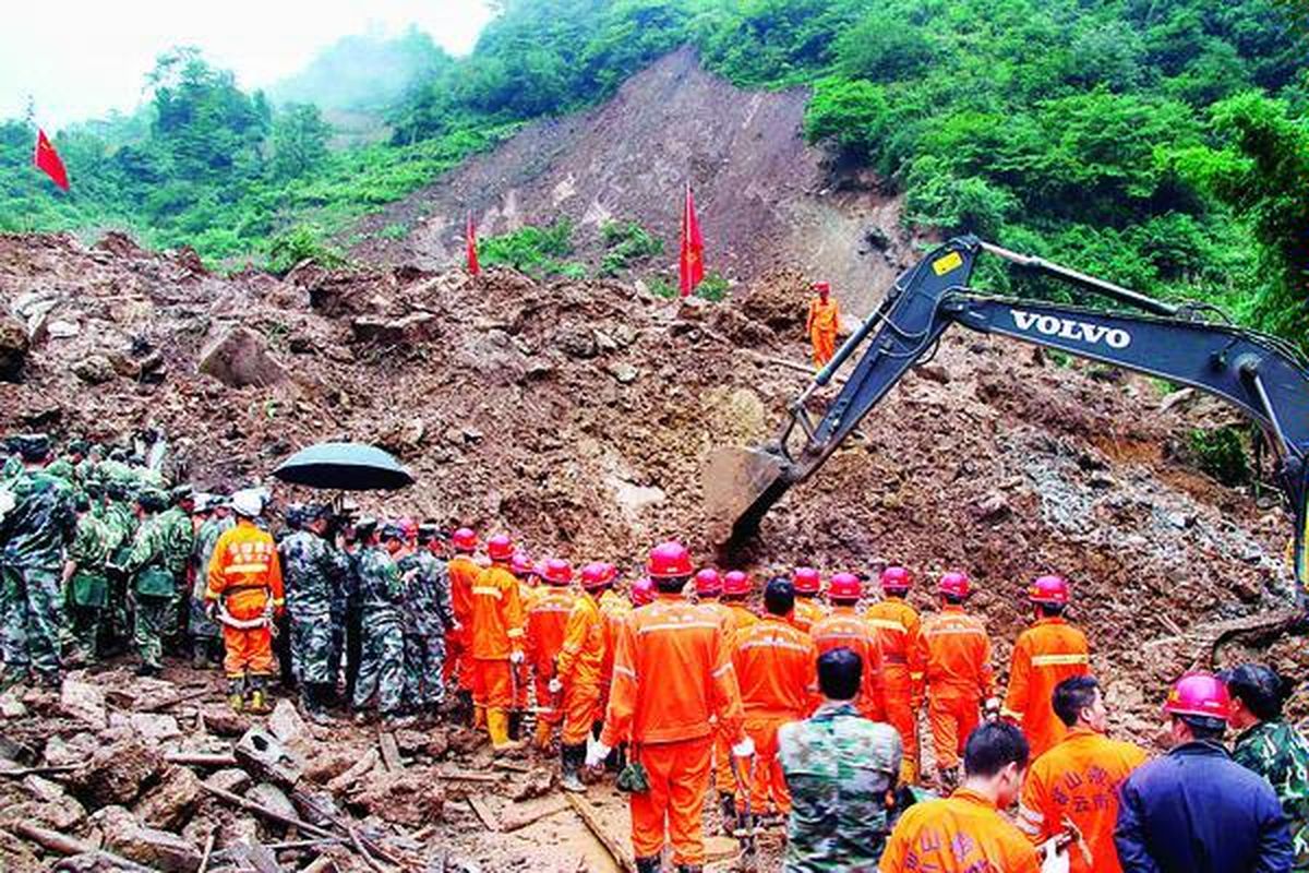 Petugas penyelamat dengan bantuan alat berat mencari korban akibat tanah longsor yang dipicu hujan deras di desa Zhenhe, Yiliang, Provinsi Yunan, China, Kamis (4/10). Sebuah sekolah dasar dan tiga rumah petani terkubur dalam bencana itu. Pemerintah mengonfirmasi 18 siswa sekolah dasar tersebut tewas.