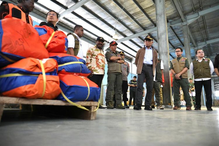 Kepala BNPB Letjen TNI Suharyanto (kiri rompi cokelat) didampingi Menko PMK Muhadjir Effendy (tengah jaket cokelat) dan Deputi Bidang Penanganan Darurat BNPB Fajar Setyawan (kanan rompi hijau) meninjau logistik yang akan dikirimkan kepada warga terdampak bencana kekeringan dan cuaca dingin ekstrem di Terminal Kargo, Bandara Mozes Kilangin, Timika, Papua Tengah, Rabu (2/8/2023).