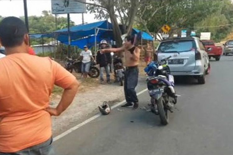 Keberatan ditilang polisi, seorang pengendara sepeda motor di Kota Mamuju, Sulawesi Barat, mengamuk sabil banting helem dan membuka baju di jalan raya.