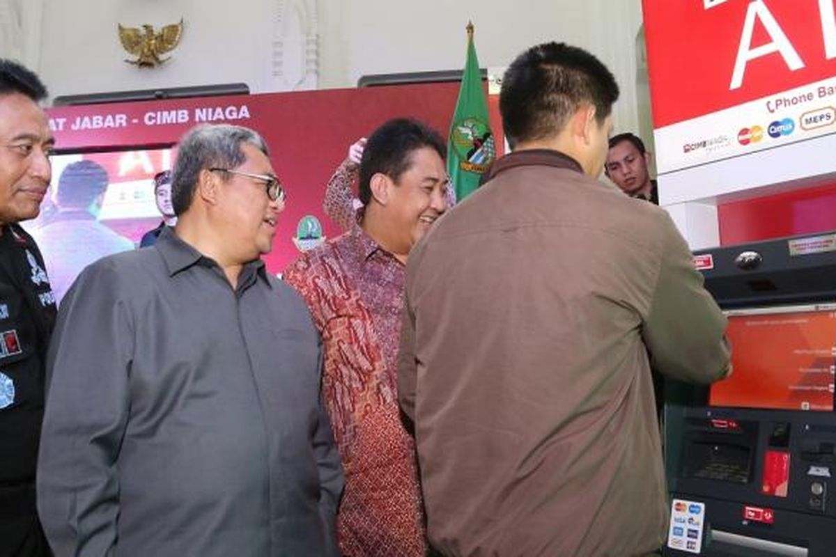 Gubernur Jawa Barat Ahmad Heryawan (kedua dari kiri) bersama Kapolda Jawa Barat Irjen Pol. Bambang Waskito (kiri), dan Head of Digital Banking, Branchless and Partnership CIMB Niaga Bambang Karsono Adi (kedua dari kanan) menyaksikan nasabah melakukan pembayaran pajak kendaraan bermotor (PKB) melalui ATM CIMB Niaga.