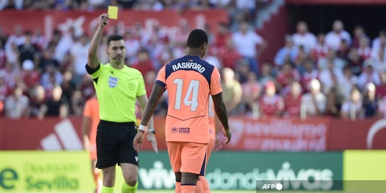 Wasit Alejandro Muniz memberikan kartu kuning kepada penyerang Barcelona Marcus Rashford pada laga Liga Spanyol antara Sevilla FC dan FC Barcelona di Stadion Ramon Sanchez Pizjuan di Seville pada tanggal 5 Oktober 2025.
