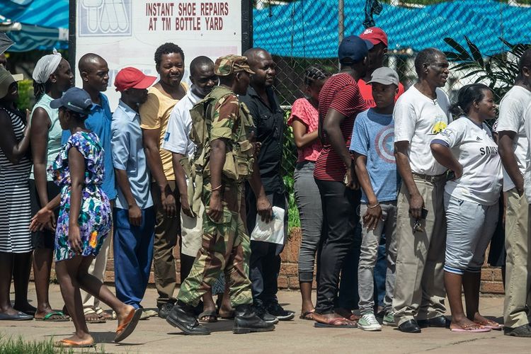 Seorang prajurit Zimbabwe mengawasi warga yang antre di sebuah pusat perbelanjaan di kota Bulawayo pada 17 January 2019. 