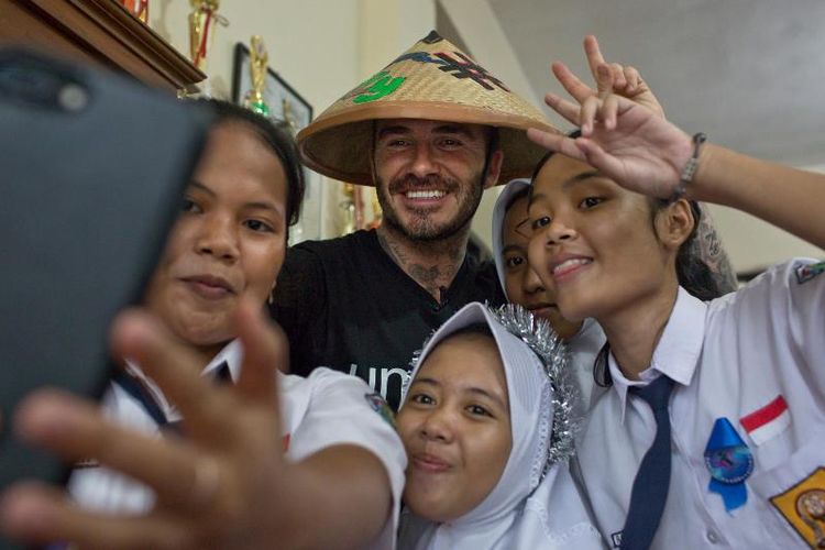 Duta Kehormatan UNICEF David Beckham berfoto bersama Sripun (15) dan para siswa di SMPN 17 di Semarang, Jawa Tengah, Indonesia, 27 Maret 2018. Sripun diunjuk oleh lingkungannya untuk menjadi agen perubahan dan berpartisipasi dalam program anti-bullying yang diinisiasi UNICEF.