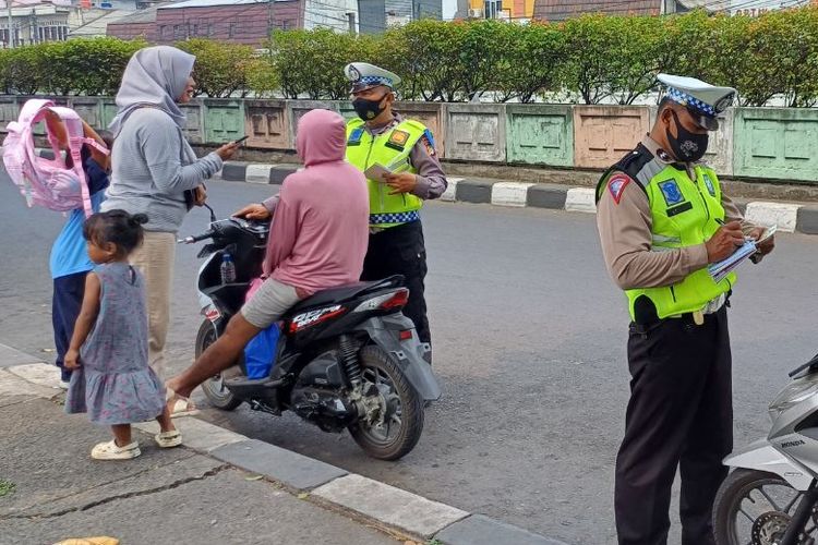 Sejumlah pemotor ditilang karena tak mengenakan helm saat melintas di depan Stasiun Pasar Minggu, Jakarta Selatan, Kamis (21/9/2023).