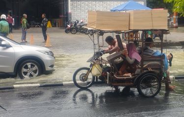 Penarik becak membawa sewa terlihat mendorong sepeda motornya karena mogok saat melintas di Jalan Dr. Mansyur, Kelurahan Selayang I, Kecamatan Medan, Kota Medan, Sumatera Utara, Minggu (12/10/2025).