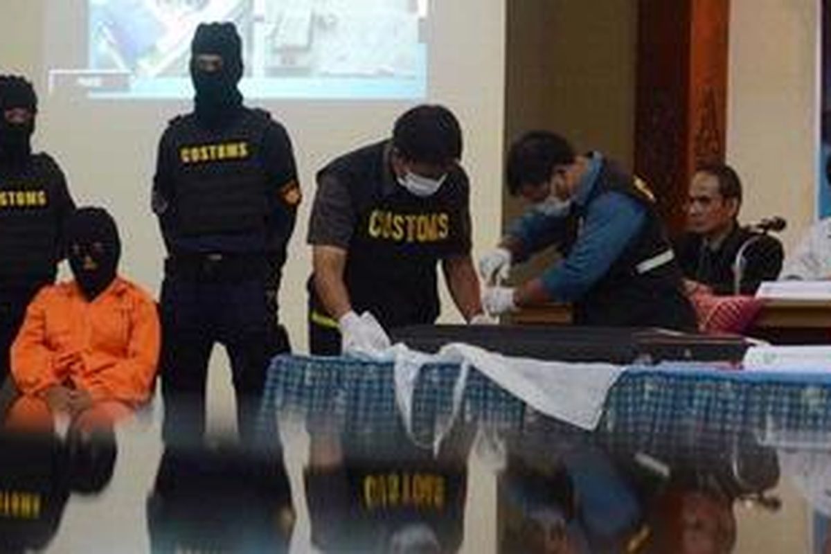 Petugas Bea dan Cukai membuka TV LCD yang digunakan oleh seorang WNI berinisial SN (berkostum oranye) untuk menyelundupkan narkoba jenis methamphetamine  (sabu-sabu) di Kantor Pengawasan dan Pelayanan Bea dan Cukai Yogyakarta, Jalan Laksda Adisucipto, Sleman, DI Yogyakarta, Sabtu (15/12/2012). Zat narkoba seberat 1.032 gram tersebut dibawa melalui penerbangan dari Kuala Lumpur, Malaysia, ke Yogyakarta sehari sebelumnya.  