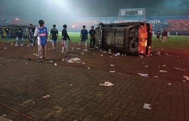 Mobil K-9 dibalik oleh supporter Aremania dalam kericuhan yang terjadi di Stadion Kanjuruhan, Sabtu (1/10/2022).