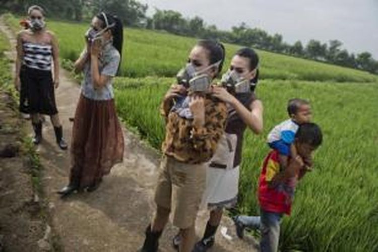 Model memakai masker gas, bersiap dalam fashion show di daerah aliran sungai yang tercemar di kawasan persawahan di Rancaekek, Bandung, dekat Sungai Citarum, 22 Maret 2015.