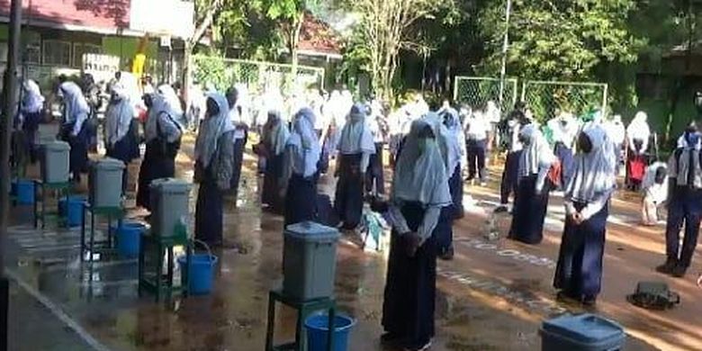 Belajar tatap muka di Kota Banjarmasin dimulai, Senin (16/11/2020). Sebelum masuk ke kelas siswa dikumpulkan dilapangan untuk mencuci tangan dan dilakukan pemeriksaan suhu tubuh.