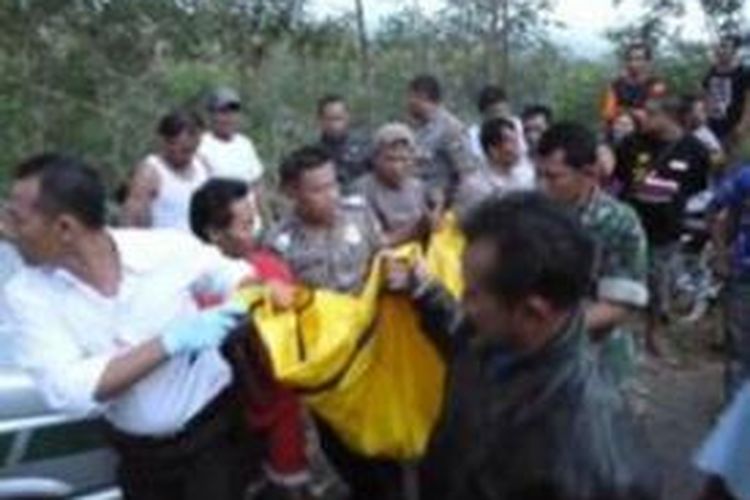 Petugas dibantu warga melakukan evakuasi mayat terikat dalam karung, Senin (11/11/2013).