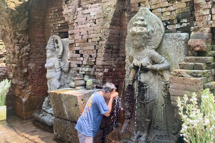 Pengunjung yang membasuh muka dengan air mengalir dari Dewi Laksmi di Candi Belahan, Pasuruan, Jawa TImur.