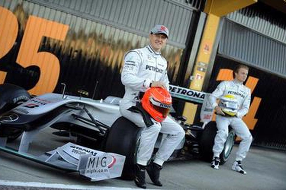 Pebalap Jerman Michael Schumacher (kiri) dan kompatriotnya Nico Rosberg, berpose di depan mobil baru Mercedes GP saat latihan pertama pra-musim di Valencia, Senin (1/2/10).