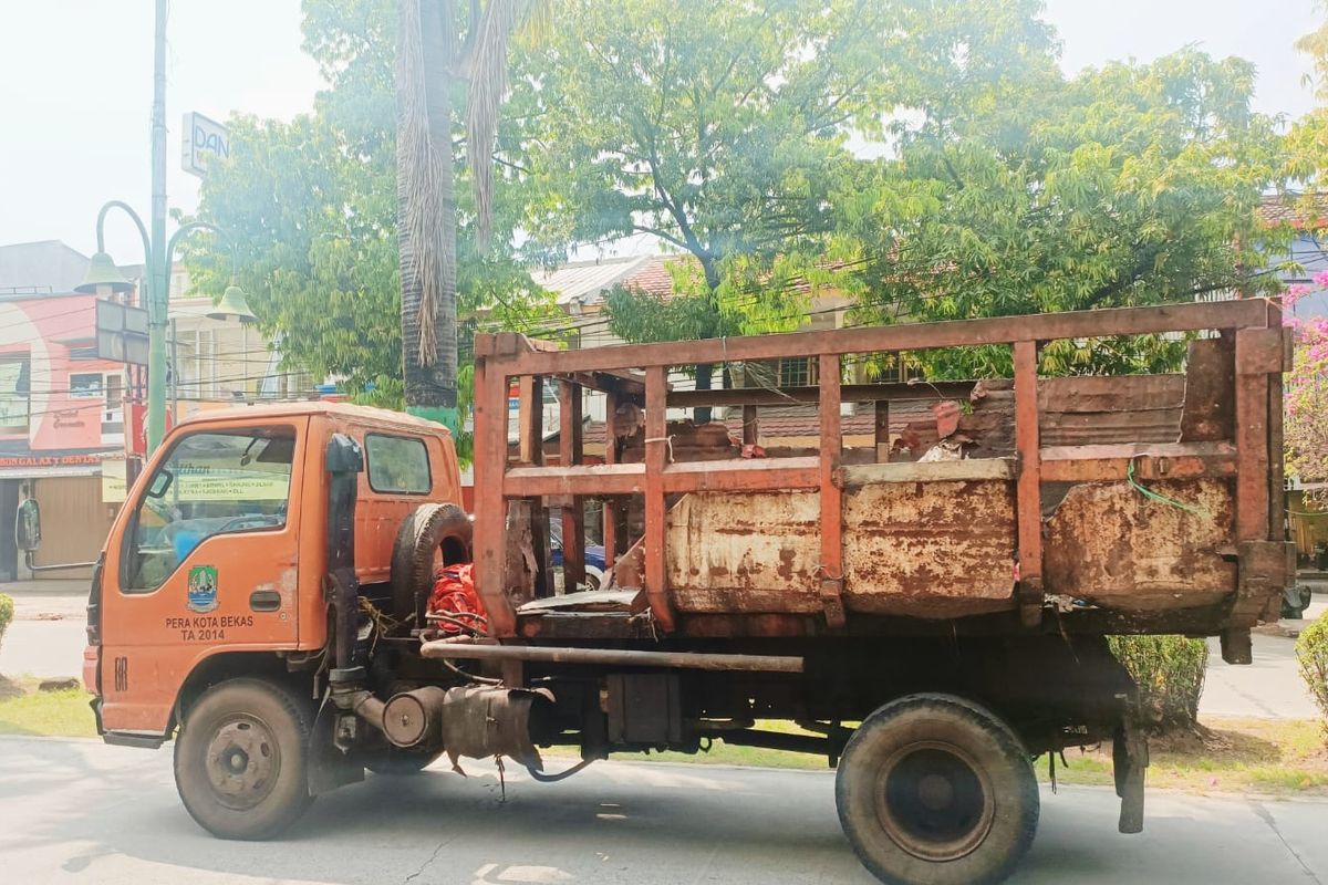 Salah satu unit truk pengangkut sampah milik Pemkot Bekasi yang cukup memprihantikan dan tidak layak jalan ketika ditemui oleh Kompas.com di Perumahan Galaxy, Cikunir, Bekasi Selatan, Kota Bekasi, Senin (16/5/2022). DLH menyebut, dari total 285 unit kendaraan pengangkut sampah milik Kota Bekasi, hanya ada sekitar 245 unit yang layak beroperasi. 