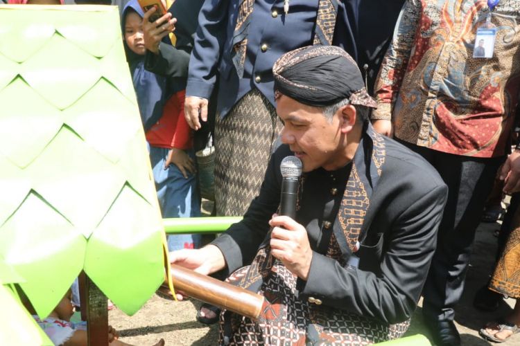 Gubernur Jawa Tengah Ganjar Pranowo mengikuti Kirab Jolen Bobok Bumbung di Cilacap, Jawa Tengah, Senin (5/3/2019). Tradisi ini ternyata dimanfaatkan warga setempat untuk membayar pajak. 