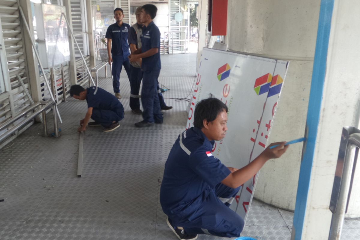 Petugas dari PT Transjakarta, Jumat (26/5/2017), mulai memperbaiki Halte transjakarta Kampung Melayu yang rusak akibat ledakan bom pada Rabu malam lalu.