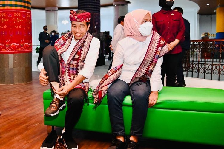 Presiden Joko Widodo didampingi Ibu Iriana Jokowi mencoba sepatu kets yang hendak dibelinya saat berkunjung ke ke Sentra Tenun Jembrana di tengah rangkaian kunjungan kerjanya di Bali, Kamis (2/2/2023) sore.
