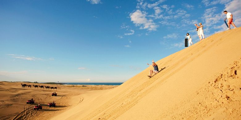 Sempatkan bermain sandboarding di gurun pasir ketika road trip.