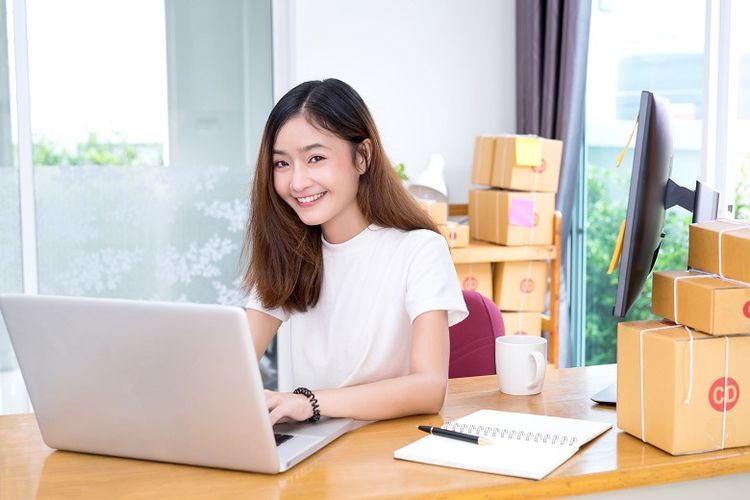 Young asian girl freelancer business private working at home office with laptop, note, coffee, packaging delivery online market on purchase orders to customer.