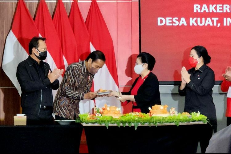 Presiden Joko Widodo saat menerima potongan tumpeng dari Ketua Umum PDI-P Megawati Soekarnoputri di Sekolah Partai PDI-P, Lenteng Agung, Selasa (31/6/2022).