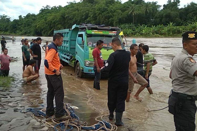 Petugas gabungan bersama warga mengevakuasi truk yang terjebak akibat luapan air Sungai Serayu di Desa Karangcengis, Kecamatan Bukateja, Kabupaten Purbalingga, Jawa Tengah, Kamis (5/3/2020).