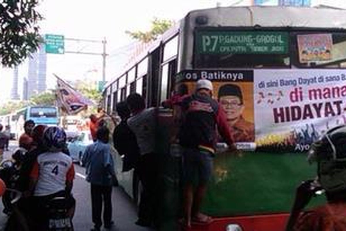 Seorang peserta kampanye pasangan Hidayat Nur Wahid-Didik J Rahbini, nekat bergelantungan di belakang bus mayasari bakti, Minggu (1/7/2012), di Jl. Rasuna Said, Jakarta Selatan.