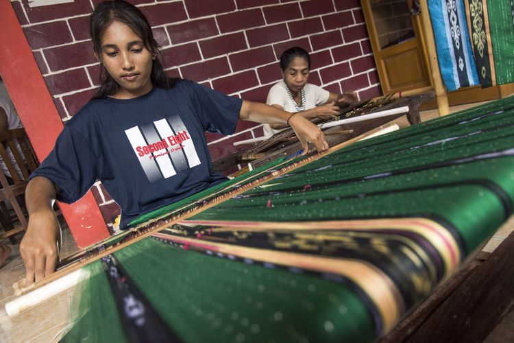 Foto dirilis Selasa (25/1/2022), memperlihatkan penenun muda dan senior kelompok Ralsasam mengerjakan pesanan tenun ikat tanimbar dengan alat tenun tradisional di Desa Tawiri, Kota Ambon. Provinsi Maluku memiliki wastra tradisional tenun ikat Tanimbar, sarat akan warisan tradisi, identitas, dan nilai kebersamaan dalam proses pembuatannya, yang dalam perkembangannya terus berevolusi dan kini dipopulerkan dengan sebutan tenun Maluku.