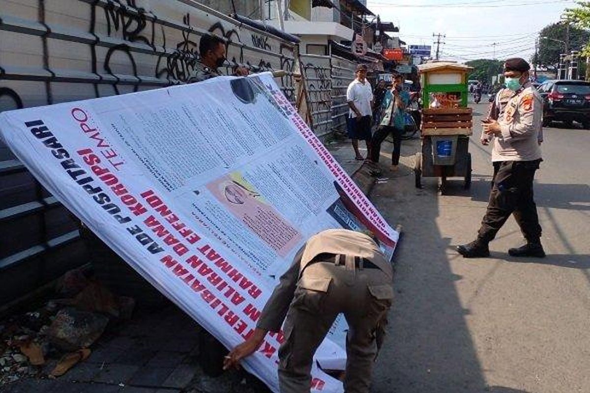 Petugas Satpol PP tengah menertibkan Baliho yang bertuliskan dukungan KPK untuk mengusut tuntas kasus korupsi yang menimpa Wali Kota Bekasi non Aktif Rahmat Effendi. (Dok. Satpol PP Kota Bekasi). 
