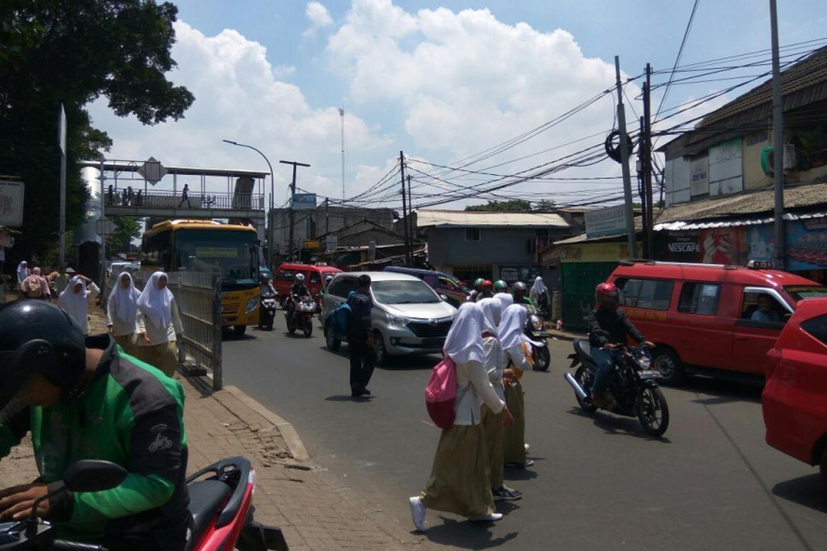 Para pejalan kaki menyeberang jalan di bawah Jembatan Penyeberangan Orang (JPO)