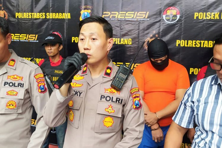 Seorang tukang parkit yang merupakan pelaku pengeroyokan saat berada di Polsek Karang Pilang, Surabaya. Tukang parkir sebuah tempat hiburan malam di Surabaya ini ditangkap karena bersama dua rekannya yang masih dalam pengejaran, mengeroyok pengunjung.