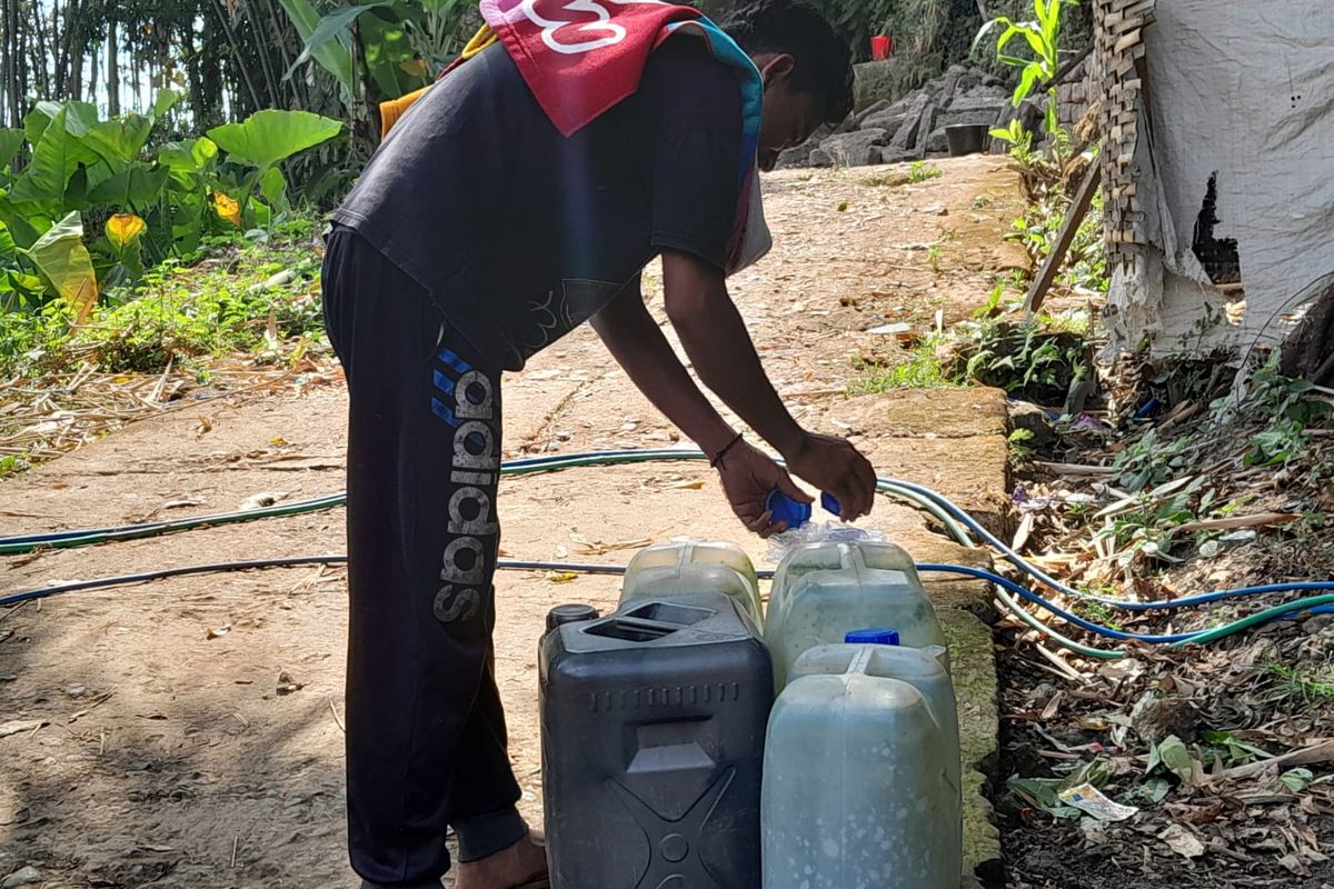 Warga mengambil air di sumber mata air di Dusun Gebang, Desa Semambung, Kecamatan Jatibanteng, Kabupaten Situbondo.