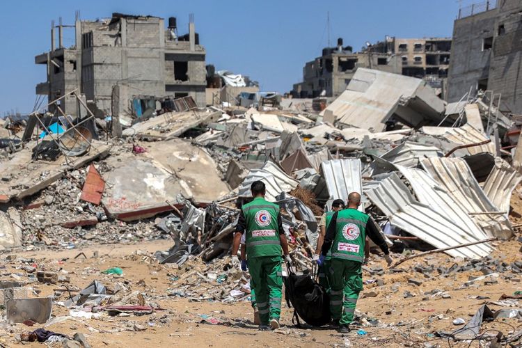 Paramedis Palestina membawa mayat-mayat yang ditemukan di sekitar Rumah Sakit Al-Shifa di Kota Gaza pada 17 April 2024 setelah operasi militer Israel baru-baru ini di sana di tengah-tengah pertempuran yang sedang berlangsung di wilayah Palestina antara Israel dan kelompok Hamas.