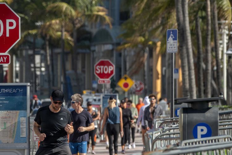 Turis masih berjalan di sepanjang jalan menuju pantai di Miami Beach di South Beach, Florida, AS, 19 Maret 2020.  EPA-EFE/CRISTOBAL HERRERA