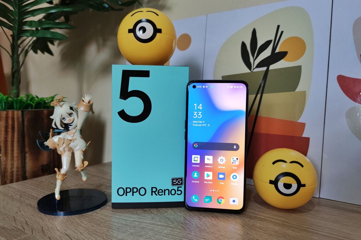 Oppo Reno5 5G bersama kotak penjualannya. Sekilas, desain kotak kemasan ponsel ini memang berbeda dengan pendahulunya, Reno4. Namun, tampilannya masih seirama dengan Reno5. Alih-alih hijau pinus pekat, kotak penjualan Reno5 5G kini dilapisi dengan warna hijau toska yang adem di mata. Ponsel ini juga terasa ringan dan nyaman digenggam dan memiliki layar yang cukup lega.
