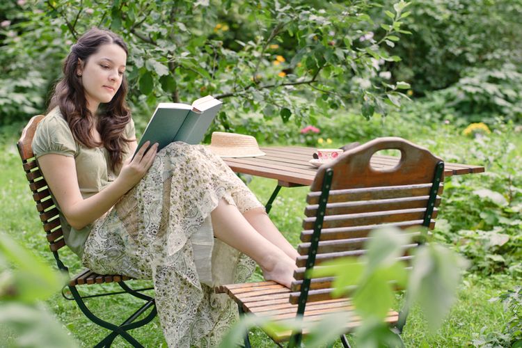 Membaca buku di halaman rumah bisa jadi aktivitas menyenangkan untuk mengusir rasa bosan di rumah saja.
