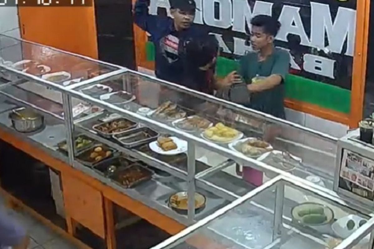 Komplotan penodong yang terdiri dari tiga pria merampas dompet dan ponsel seorang pria yang sedang  makan di sebuah rumah makan di Petukangan Utara, Pesanggrahan, Jakarta Selatan, Senin (20/1/2020) malam. Dalam gambar tampak dua dari mereka sedang mengancam korban yang membelakangi kamera.