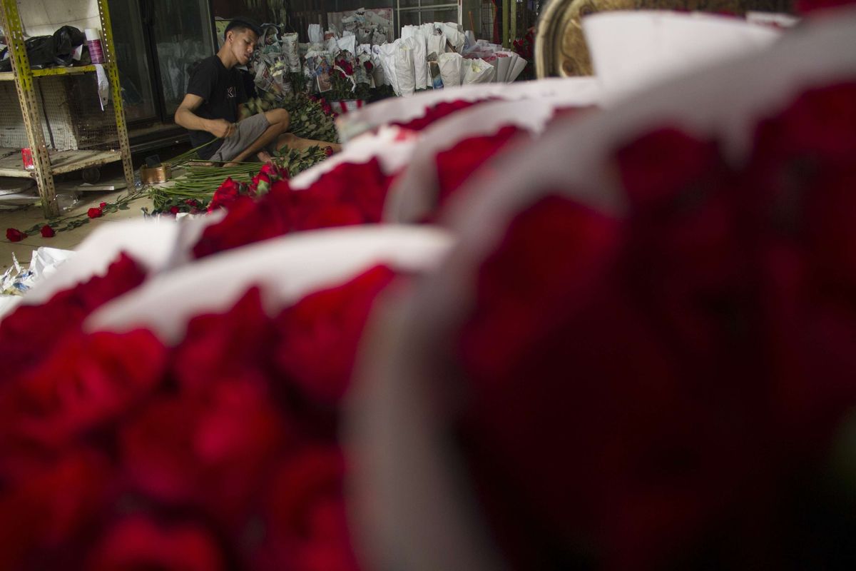 Penjual menyelesaikan pengemasan bunga mawar merah asal Malang di kawasan Pasar Bunga Rawa Belong, Sukabumi Utara, Kebon Jeruk, Jakarta Barat, Senin (10/2/2020). Menjelang valentine, harga bunga mawar merah di Pasar Rawa Belong naik.