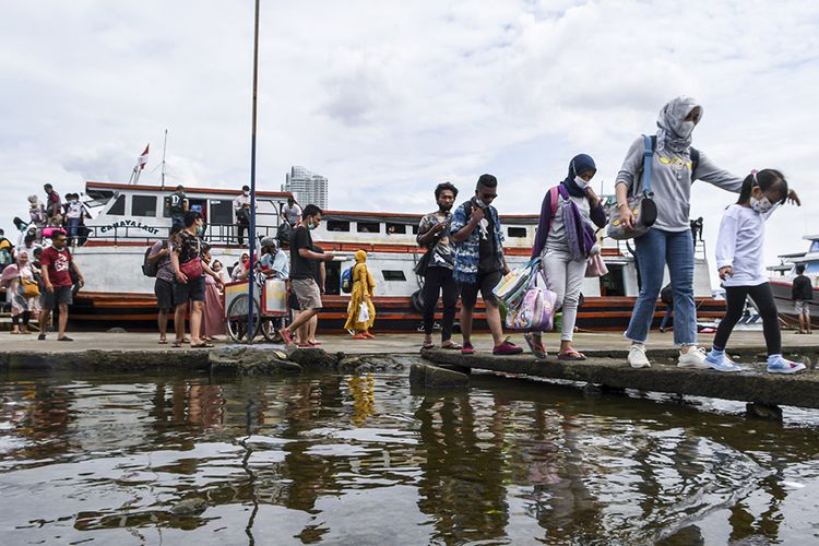 Sejumlah penumpang kapal dari Kepulauan Seribu tiba di Dermaga Kali Adem, Muara Angke, Jakarta, Sabtu (26/12/2020). Menurut data dari Suku Dinas Pariwisata dan Ekonomi Kreatif (Sudin Parekraf) Kepulauan Seribu sebanyak 3.018 wisatawan berkunjung di Kepulauan Seribu seperti Pulau Tidung, Pari, dan Pramuka untuk mengisi liburan Natal 2020 dengan pengawasan ketat protokol kesehatan guna mngantisipasi penularan COVID-19.