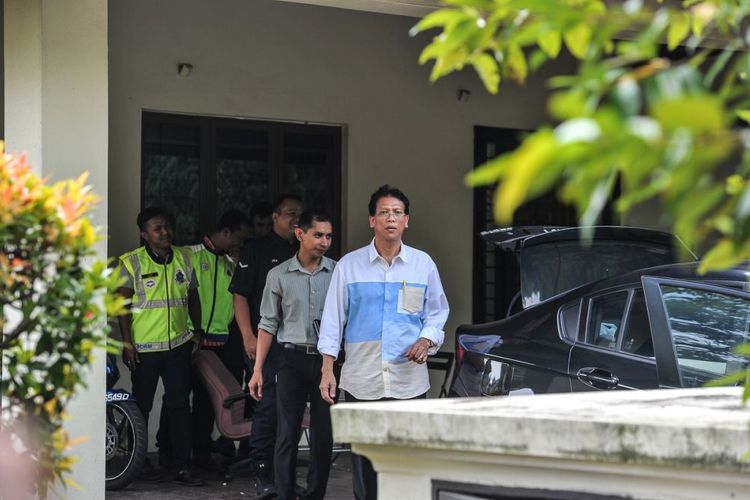 Beberapa polisi berompi keluar dari rumah yang diduga milik eks Perdana Menteri Malaysia Najib Razak Senin (11/6/2018).