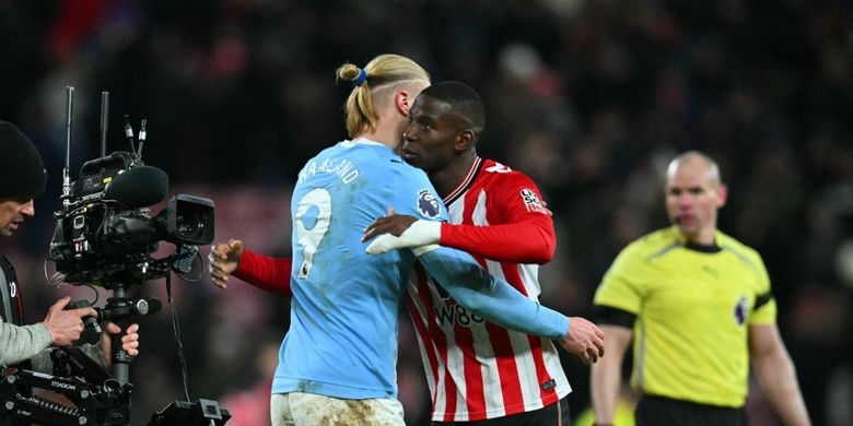 Penyerang Manchester City, Erling Haaland, bercengkrama dengan bek Sunderland, Nordi Mukiele, usai pertandingan pekan ke-19 Premier League Sunderland vs Man City yang berakhir imbang dengan skor kaca mata di Stadium of Light pada Jumat (2/1/2026) dini hari WIB.