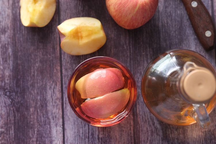Ilustrasi cuka apel di dalam gelas dan botol. 