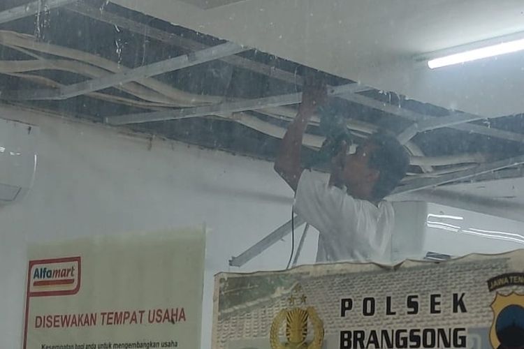 Karyawan Alfamart saat memperbaiki atap toko yang rusak dibobol maling.